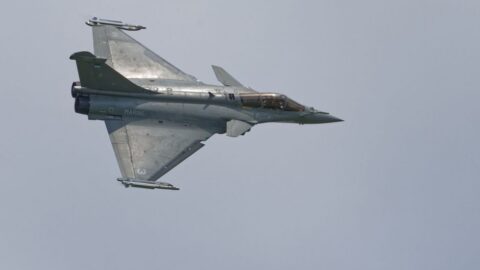 Two-seat gray US Marine Corps fighter jet in level flight, twin engines with swept wings and a closed cockpit canopy.